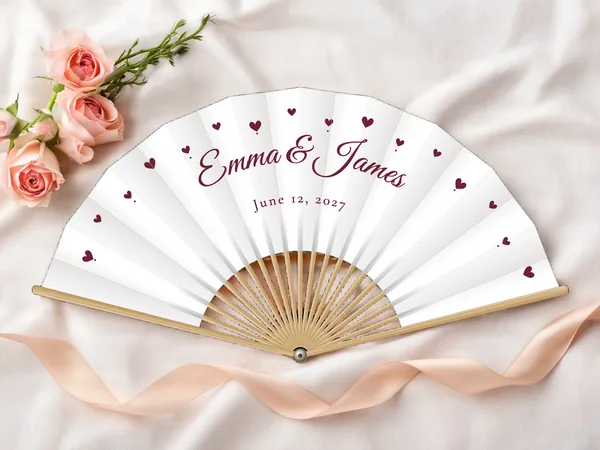 Personalized wedding fan "Little Hearts" with the names Emma & James, little hearts scattered all around, white fabric with burgundy print, on a wedding table