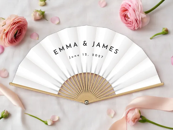 Personalized wedding fan "Minimalist" with the names Emma & James, no motif, just the lettering in capitals, white fabric with black print, on a wedding table